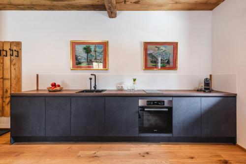a kitchen with black cabinets and a counter top at Appartementhaus Plainstöckl Hotel Gasthof Maria Plain in Salzburg