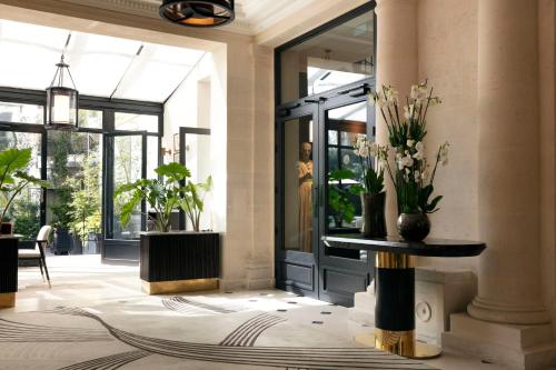 a lobby with a vase of flowers on a table at Les Jardins du Faubourg Hotel & Spa by Shiseido in Paris