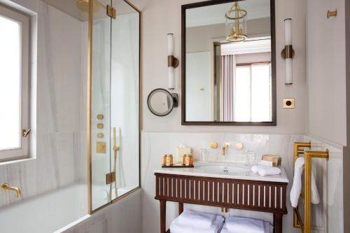 a bathroom with a sink and a mirror at Les Jardins du Faubourg Hotel & Spa by Shiseido in Paris