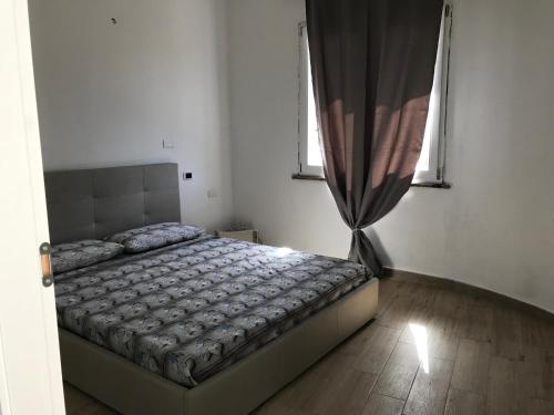 1 dormitorio con cama y ventana en Casa vacanze “ gli orizzonti “ appartamento Ninfea, en Domusnovas