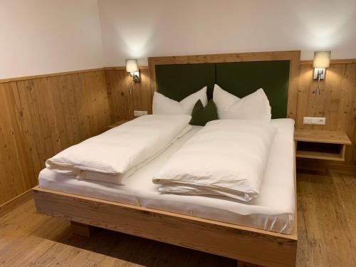 a large bed with white pillows in a room at Kererhof in Kals am Großglockner