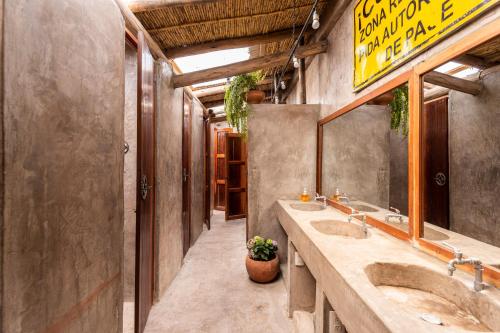 een badkamer met 2 wastafels en een grote spiegel bij Wolf Totem Steam Punk Guesthouse in Pisac