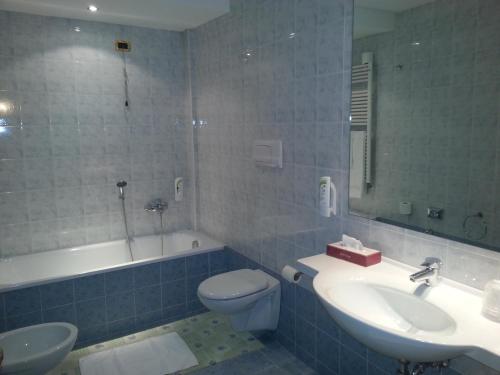 a bathroom with a sink and a toilet and a tub at Albergo Costantini in Tarcento