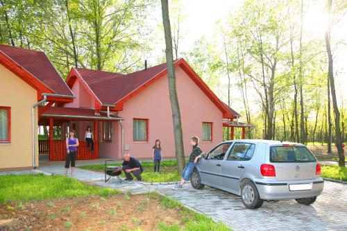 a group of people standing outside of a house at Sárkány Apartman, Sárkány Wellness és Gyógyfürdő in Nyírbátor