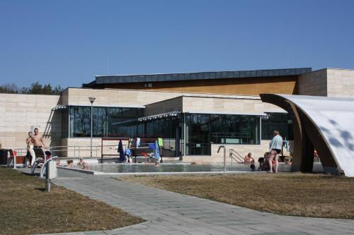 a building with a swimming pool in front of a building at Sárkány Apartman, Sárkány Wellness és Gyógyfürdő in Nyírbátor