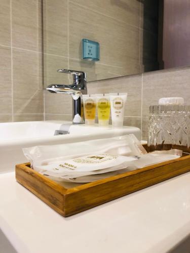 a wooden tray sitting on top of a bathroom sink at Luxury Condotel 2BR Vinhomes Skylake Keangnam - Netflix free in Hanoi