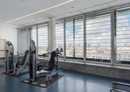 a gym with treadmills and elliptical machines and windows at Camplus Turro Casa per Ferie in Milan