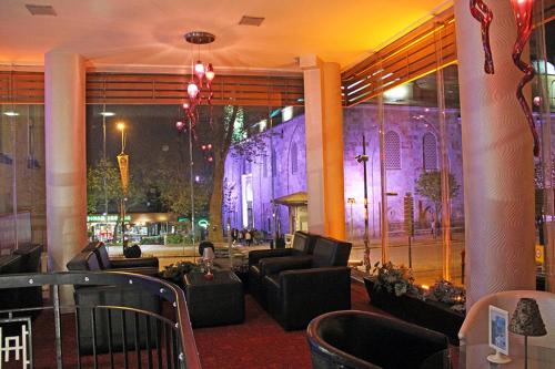 a lobby with couches and a building with purple lights at Hotel Artiç in Bursa