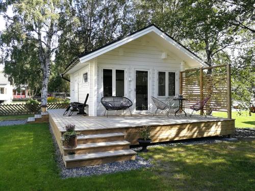 mały, biały domek z werandą i tarasem w obiekcie 25 kvadrat 25 minuter från Åre w mieście Järpen