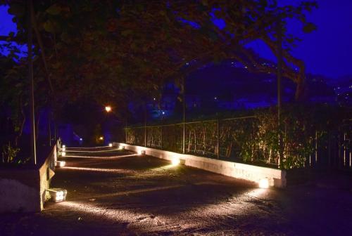 a path with lights on a fence at night at Portico Del Paradiso in Scala