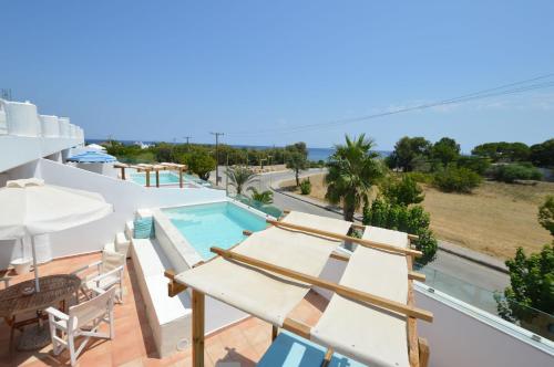a villa with a swimming pool and a view of the ocean at Kathara Bay Apartments in Faliraki
