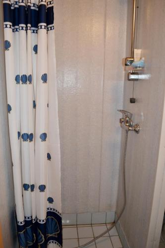 a shower with a blue and white shower curtain at Rosma Mill Holiday House in Põlva