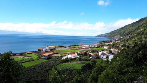 a small town on a hill next to the ocean at Casa Grão de Café AL in Fajã dos Vimes