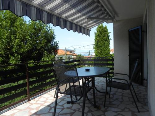 a patio with a table and chairs on a balcony at Apartments Katalenić in Selce