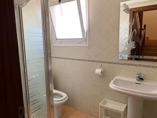 baño con aseo y lavabo y ventana en Casa Katrina, en Tías