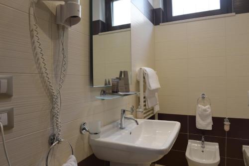 a bathroom with a sink and a mirror and a toilet at Imperiali Hotel in Francavilla Fontana