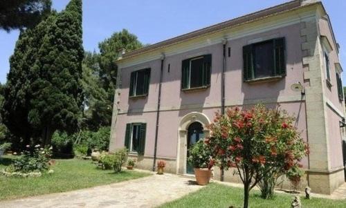 una casa grande con un árbol delante en Ai Cipressi, en Salemi