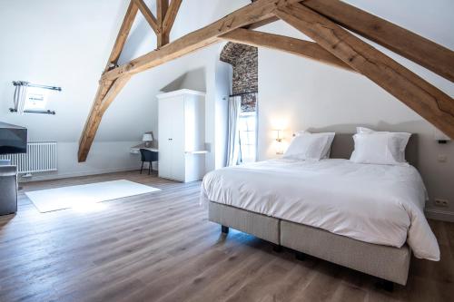 a bedroom with a large white bed and wooden floors at Bed & Breakfast Jezuietenplein 21 in Oudenaarde