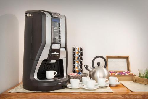 a coffee maker and coffee cups on a table at B&B I Tre Olivi in Colà di Lazise