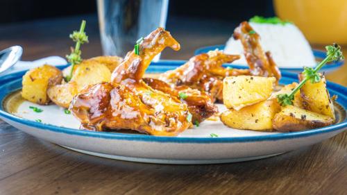 a plate of food with chicken and potatoes on a table at La Posada De Los Arcángeles in Madrid