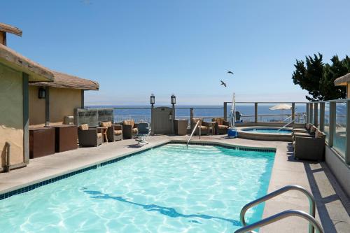 a swimming pool with a view of the ocean at Cottage Inn by the Sea in Pismo Beach