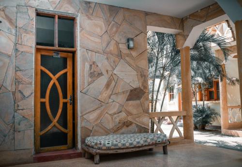 a door to a building with a bench in front of it at The Paradise In Kilimanjaro in Moshi