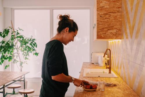 a woman standing in a kitchen preparing food at Blai Blai Hostel in Zarautz