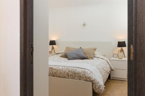 - une chambre blanche avec un lit et deux lampes dans l'établissement Appartement de standing 8 Personnes centre historique de Colmar, à Colmar