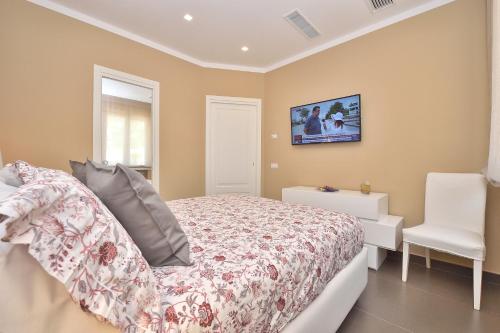 sypialnia z łóżkiem i białym krzesłem w obiekcie Costa d'Amalfi Apartments w mieście Minori
