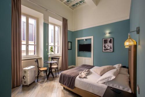 My Trevi Charming & Luxury Rooms في روما: غرفة نوم بجدران زرقاء وسرير وطاولة