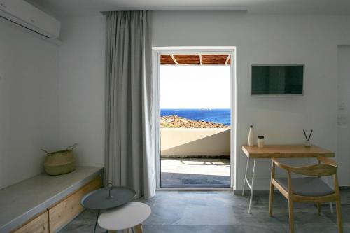 a room with a table and a view of the ocean at Pharos Apartments in Gavrio