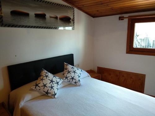 a bedroom with a bed with two pillows on it at O Tipico in Ribadavia