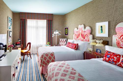 a hotel room with two beds and a desk at Graduate by Hilton Columbia SC in Columbia