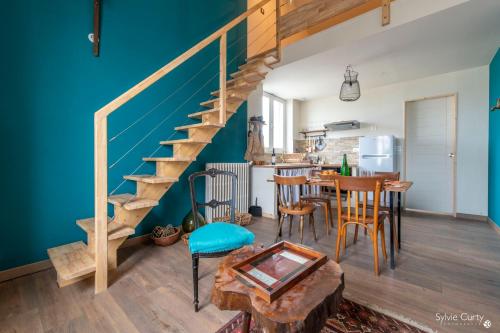 un salon avec un mur bleu et un escalier dans l'établissement Les EcoloGites de la Rochelle, à La Rochelle