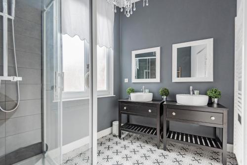 une salle de bain avec deux lavabos et une douche dans l'établissement Suite PREMIUM LE FIGARO 1, à Épernay