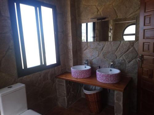 a bathroom with two sinks on a wooden counter at La Atalaya in Benaocaz