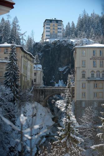 a bridge over a river in a city with buildings at Sonnenwende by AlpenTravel in Bad Gastein