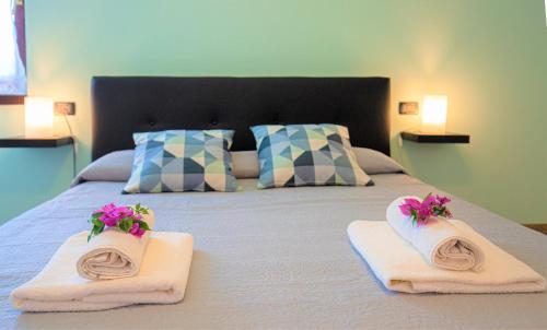 um quarto com uma cama com toalhas e flores em B&B Villa Apuana em Marina di Carrara