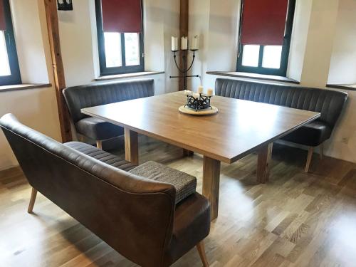 einen Esstisch mit Stühlen und einem Holztisch in der Unterkunft Ferienwohnung LATERNENSTUBE mit großem Familienbett für 8 Personen in Leppersdorf