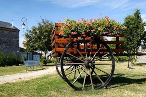 a wooden cart with flowers on it in the grass at Ancienne Fermette le Charlemont Givet Foisches in Foisches