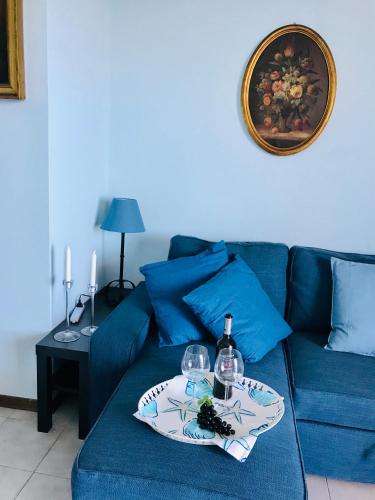 a blue couch with a plate and wine glasses on it at Little Paradise in Taormina