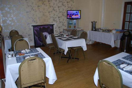 
a dining room table with chairs and a television at Madeira Hotel in Birmingham
