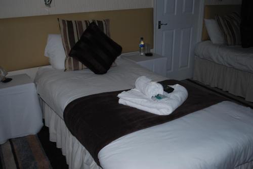 
a bed with a white blanket and pillows on top of it at Madeira Hotel in Birmingham
