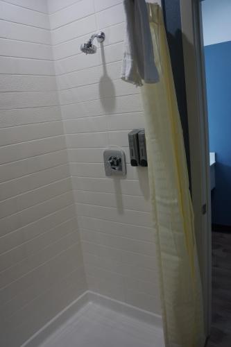 y baño con ducha y cortina de ducha. en Texan Hotel en Corpus Christi