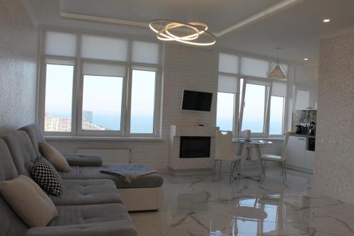 a living room with a couch and a living room with windows at M&P VIP Appartments in Arkadia in Odesa