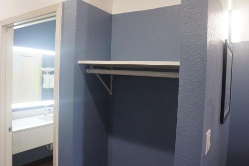 a bathroom with a blue wall with a shelf at Texan Hotel in Corpus Christi