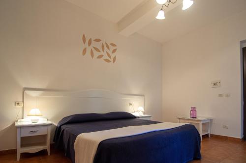 a bedroom with a large bed and two night stands at Giardino Degli Ulivi Resort Masseria in Margherita di Savoia