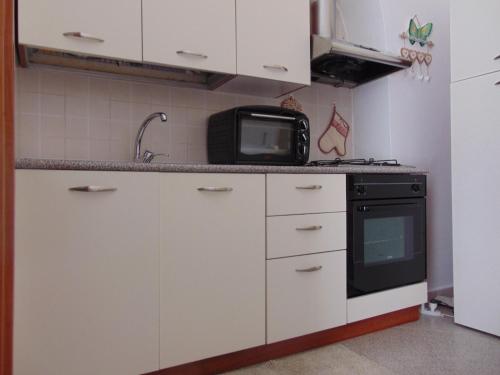 eine Küche mit weißen Schränken und einer Mikrowelle in der Unterkunft Dreams room in Bari