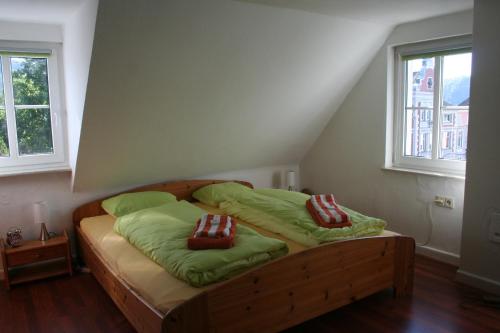 1 Schlafzimmer mit einem Bett mit grüner Bettwäsche und 2 Kissen in der Unterkunft Grillglut in Arnsberg