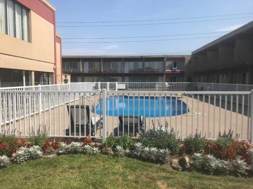 a swimming pool with two chairs and a fence at Auberge Royal Versailles in Montréal